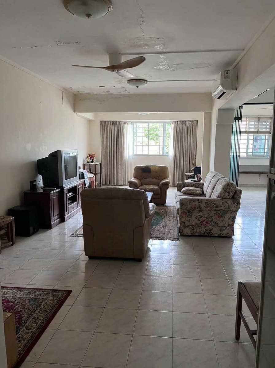 Old HDB living room with damaged ceiling and dated furniture