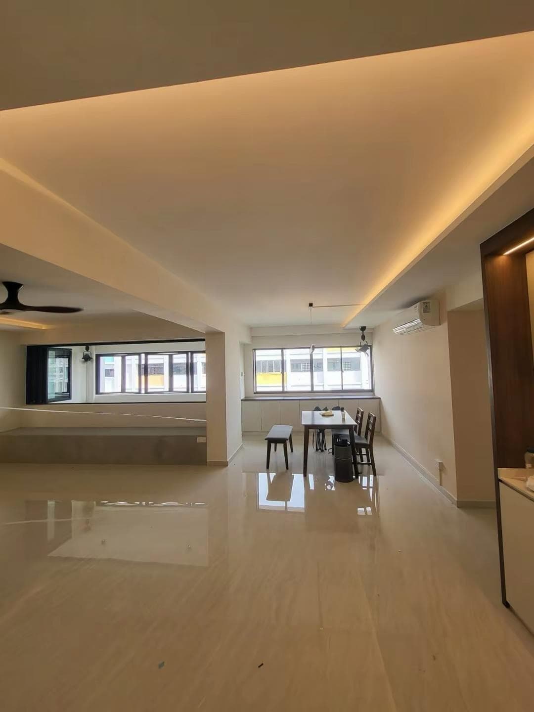 Modern open-concept living with cove lighting and polished floors